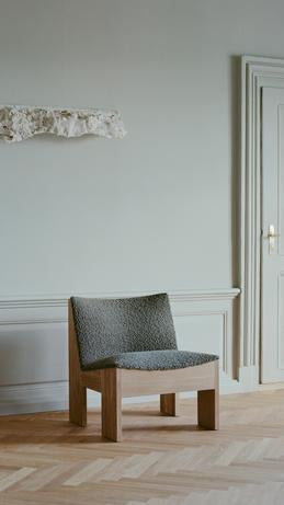 Tenon upholstered armchair with an oak base