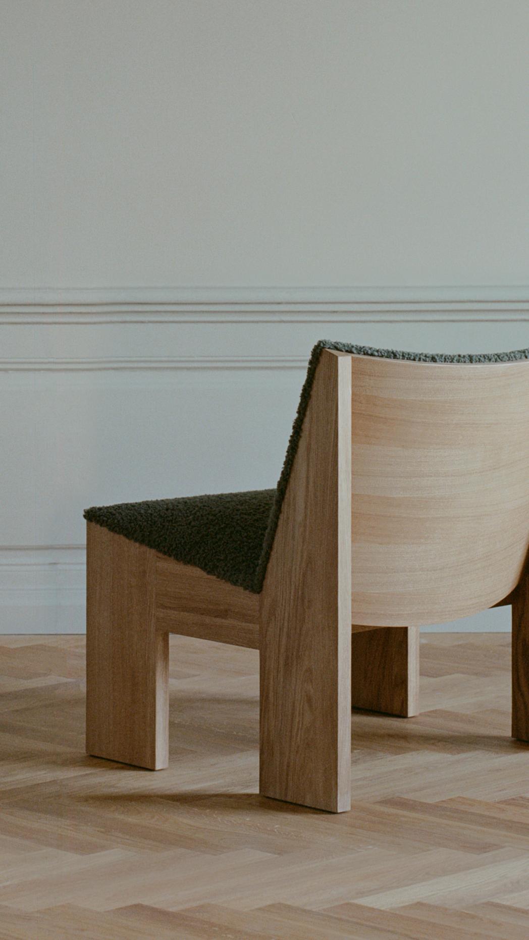 Tenon upholstered armchair with an oak base