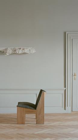 Tenon upholstered armchair with an oak base