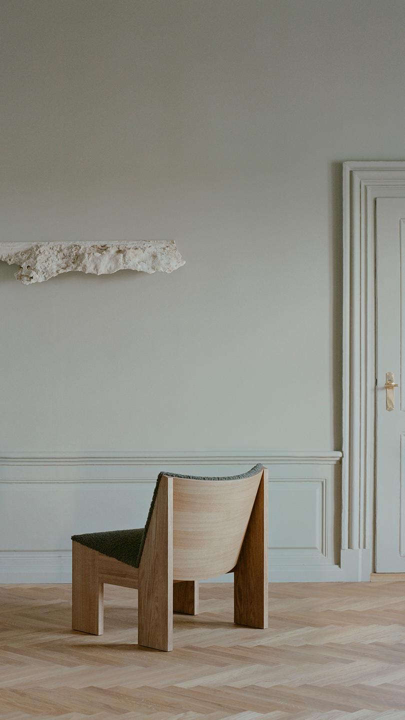 Tenon upholstered armchair with an oak base