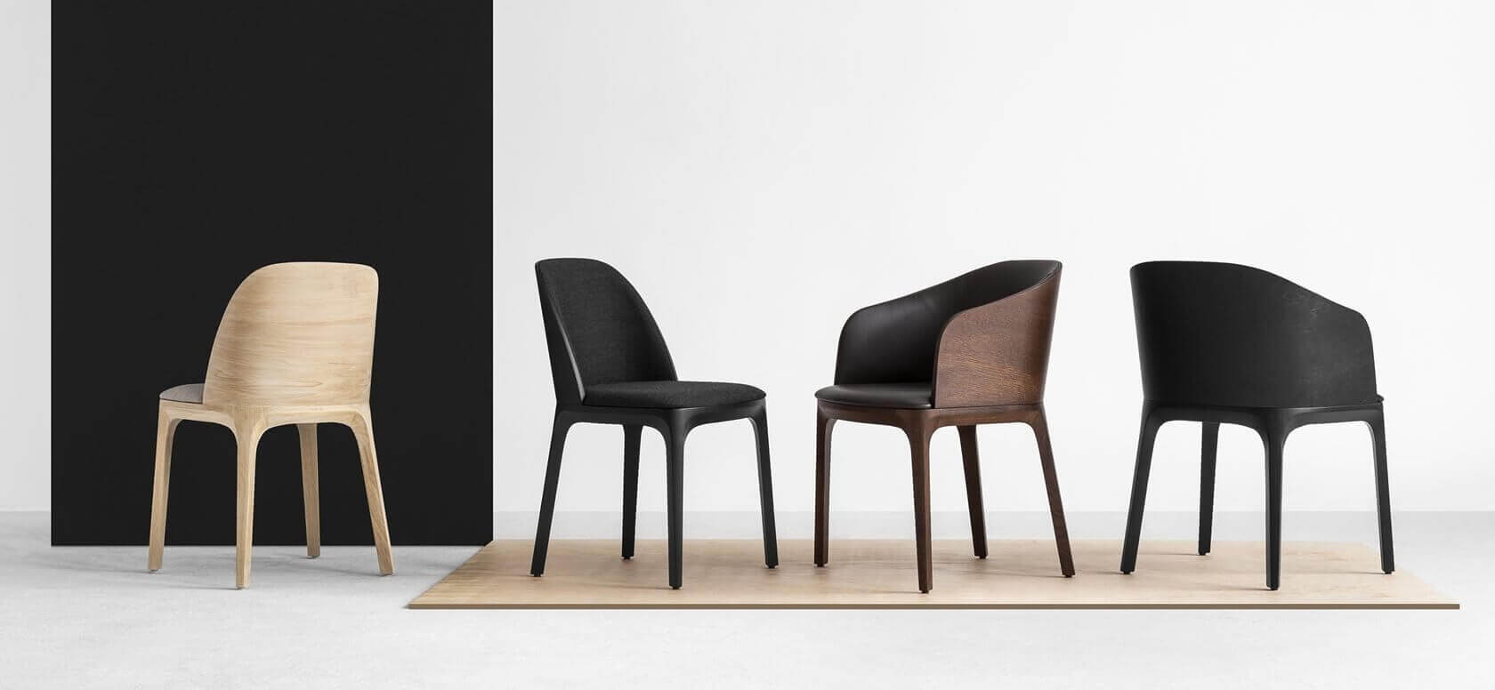 Monochromatyczna grafika przedstawia czarne krzesła w drewnianej, ciemnobrązowej ramie na białym tle oraz jedno krzesło z tego samego modelu w kolorze kremowym na czarnym tle. Grafika jest spójna i ciekawa.