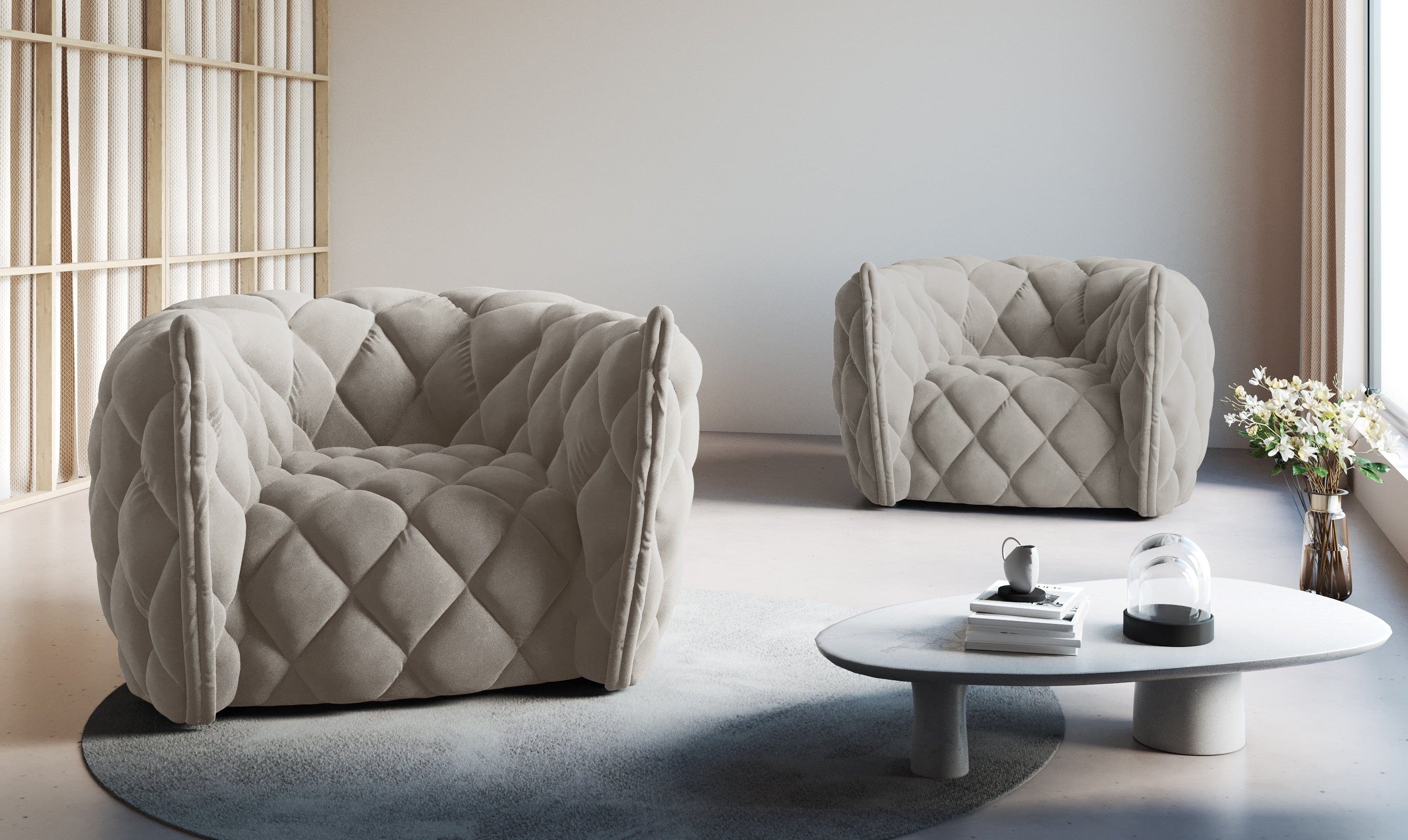 Na zdjęciu znajdują się dwa niebanalne fotele wykonane z charakterystycznego, pikowanego materiału. Fotele w kolorze beżowym wyróżniają się minimalistycznym designem i prostą formą połączoną z ciekawą fakturą.